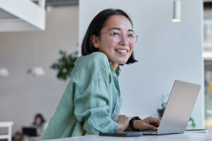smiling woman on her laptop searches signs you are recovering from anxiety