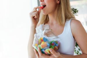 A woman wondering, "Why do people addicted to drugs eat a lot of candy?"