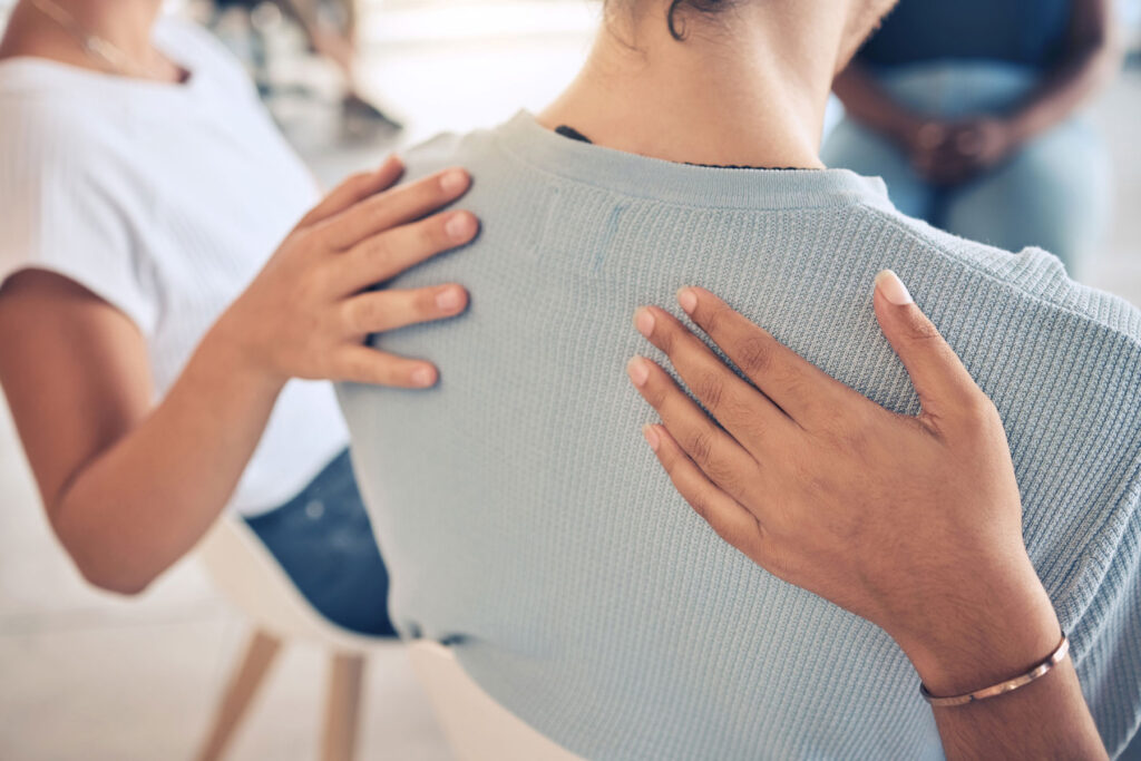a woman receives support in a therapy group for childhood trauma and addiction