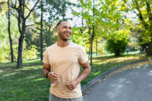 a young man jogs in the park in substance abuse recovery