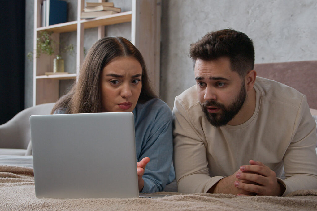 a couple looks up the health effects of alcohol abuse on a laptop