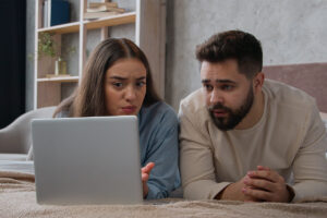 a couple looks up the health effects of alcohol abuse on a laptop